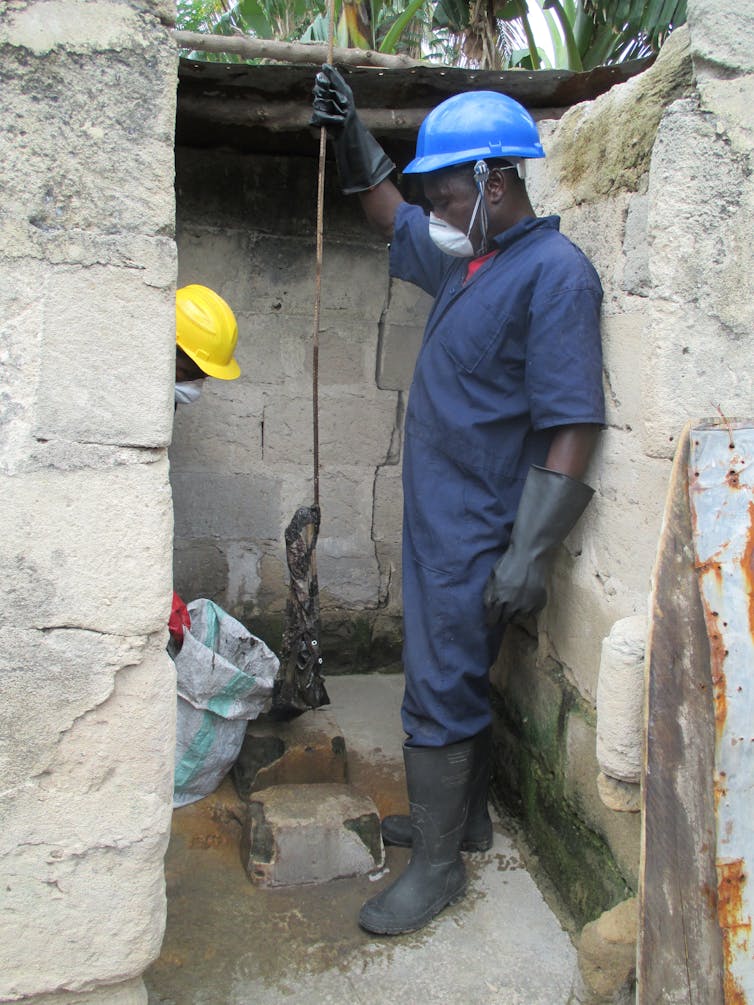 A man emptying a pit latrine in urban Tanzania