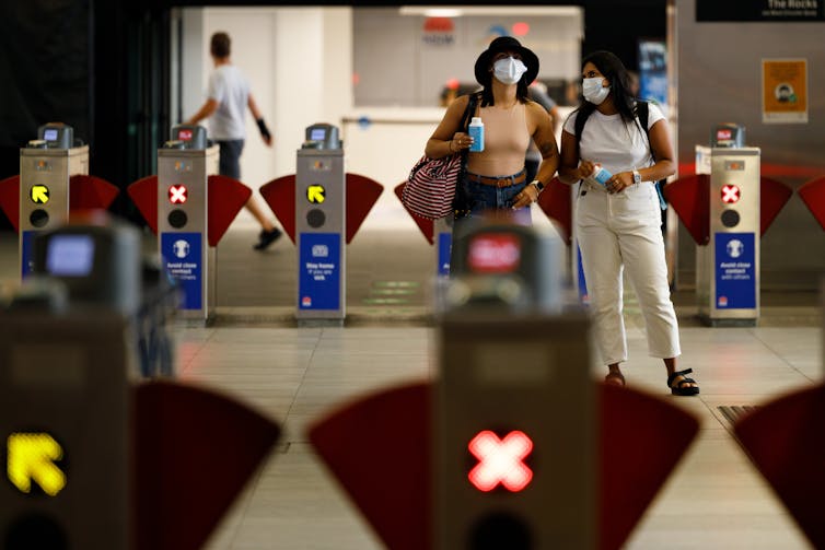 People wearing facemasks at a train station in Sydney