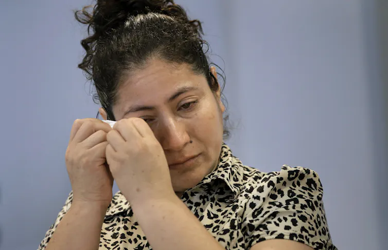 A Guatemalan mother cries at a news conference.