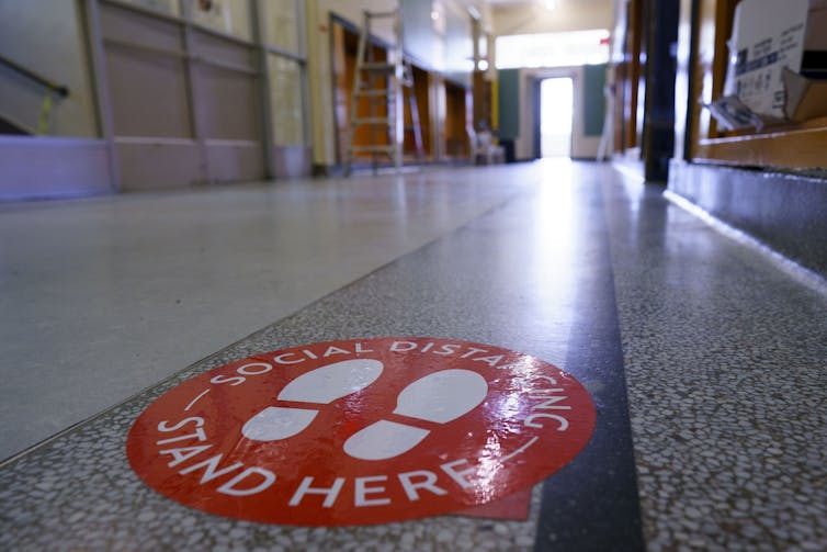 Red social distancing marking on a floor