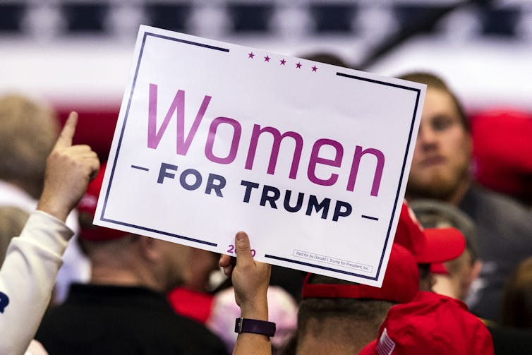 Woman holds up pro-Trump sign at election rally in February 2020.