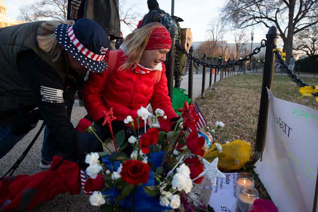 Two women placing flowers on a memorial for Ashli Babbitt who was killed while storming the US Capitol on January 6 2020.