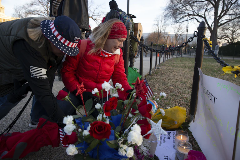 Two women placing flowers on a memorial for Ashli Babbitt who was killed while storming the US Capitol on January 6 2020.