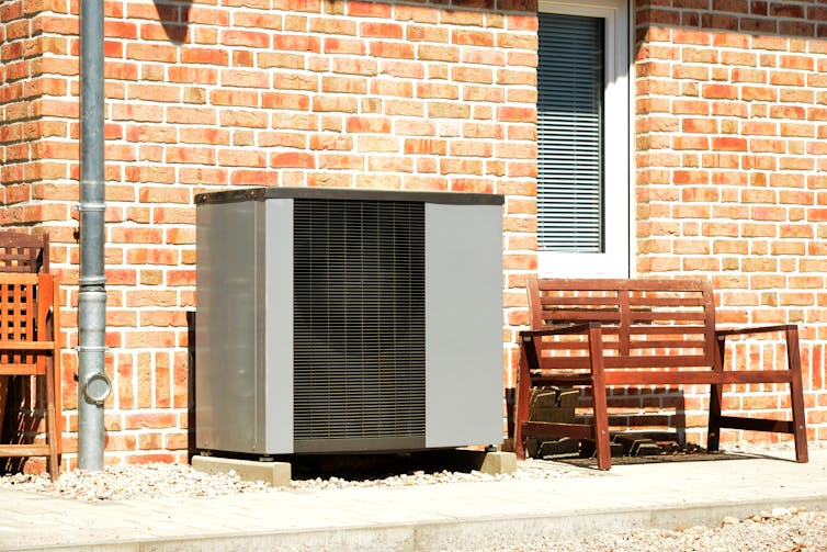 Air heat pump for heating and hot water in front of an apartment building.