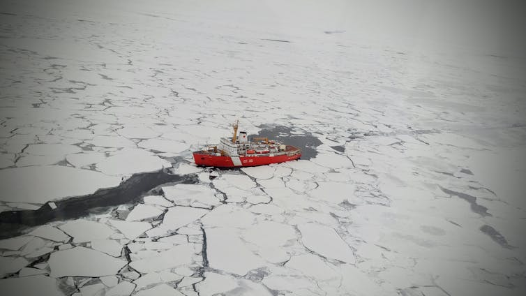 An icebreaker cuts a path through the ice floe in the Arctic Ocean.