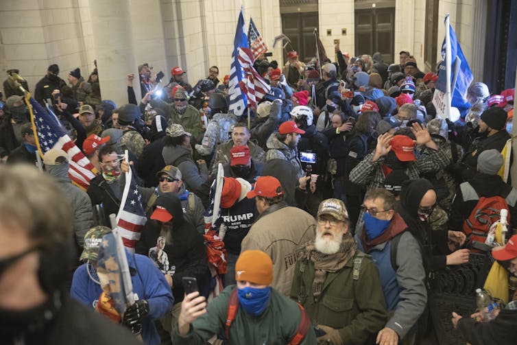 Pro-Trump protesters fill the U.S. Capitol building, many of them wearing military gear.