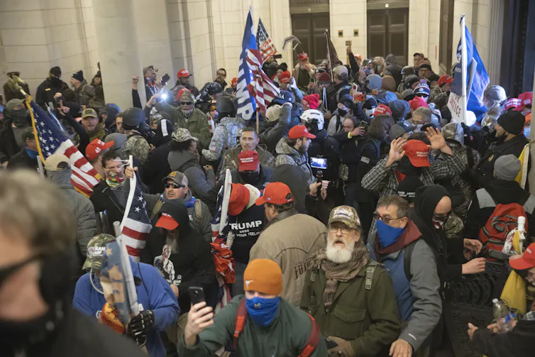 Pro-Trump protesters fill the U.S. Capitol building, many of them wearing military gear.