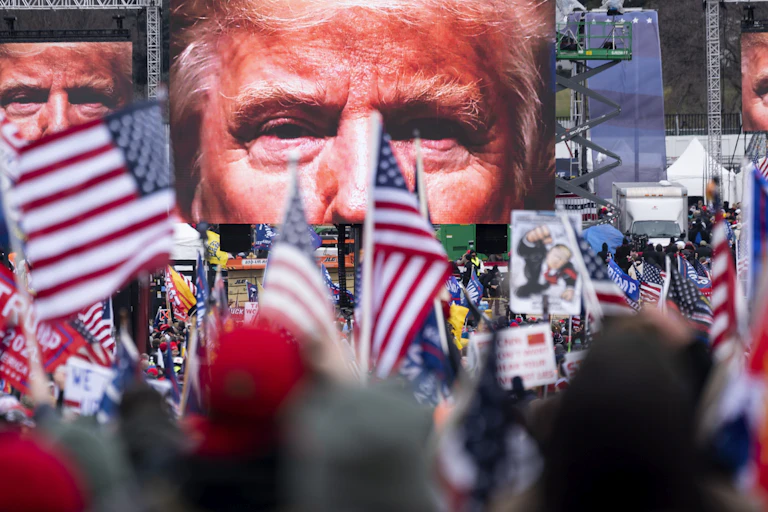 A video screen displaying Donald Trump's face as he prepares to address a crowd of his supporters.