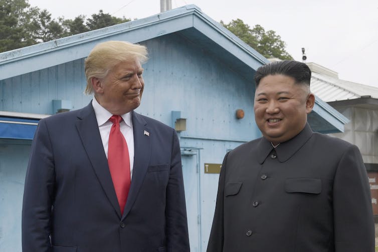 Trump smiles at North Korean leader Kim Jong Un.