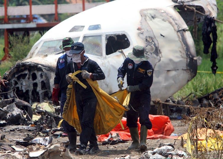 Workers clear the wreckage of the Garuda Indonesia Boeing 737-400 crash at Adisutjipto International Airport, Yogyakarta, March 11 2007.