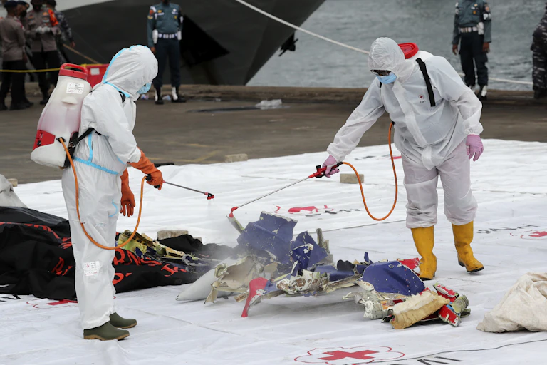 Workers disinfect parts of Sriwijaya Air Flight 182 recovered from the waters off Jakarta, Indonesia, January 10 2021.