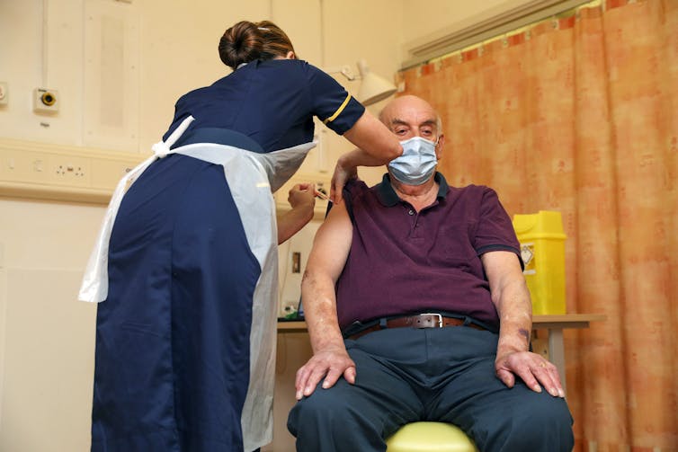 Person receiving the Oxford-AstraZeneca COVID vaccine in England.