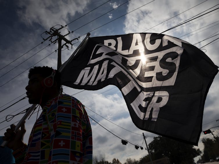 Protester carrying a 'Black Lives Matter' flag