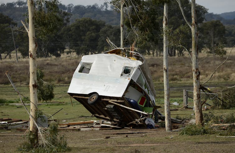 A caravan lies on its side after a storm.