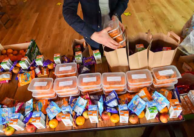 A man packs brown bags of food for families in need. 