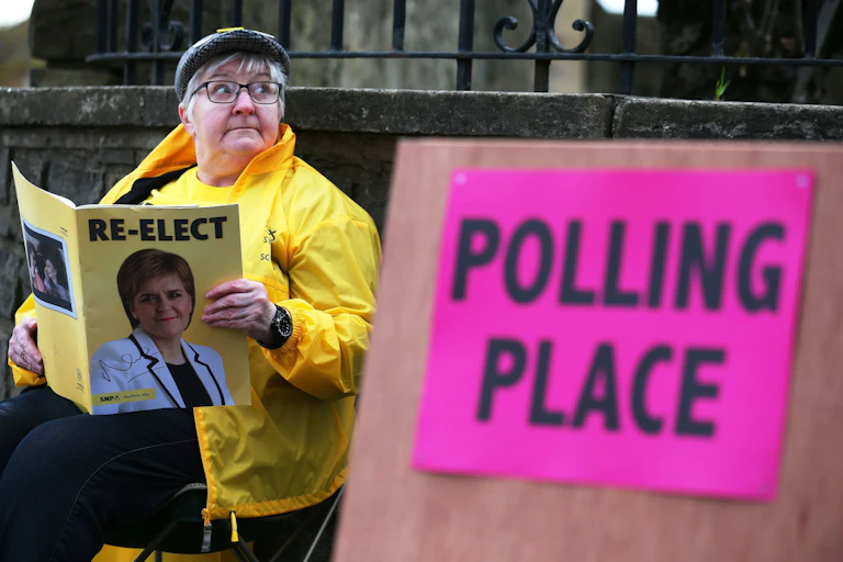 A womam reading SNP election literature