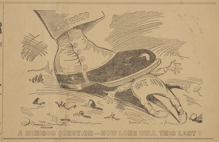 A racist political cartoon by Norman Jennett showing a boot worn by a Black man smashing a white man underneath.