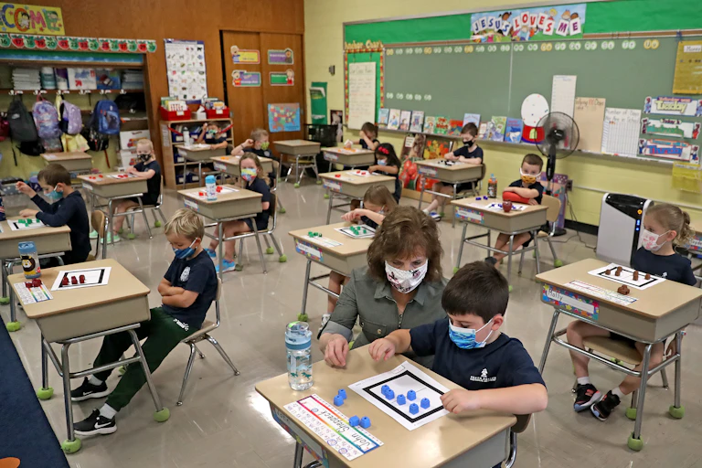 A teacher helps a helps a student in class.