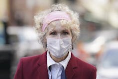 E. Jean Carroll, wearing a mask, arrives at a courthouse.