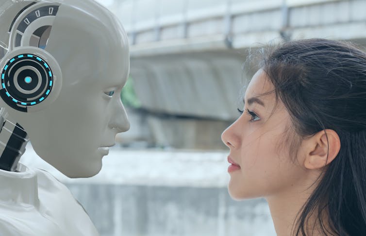 Human woman and robot stare at each other.