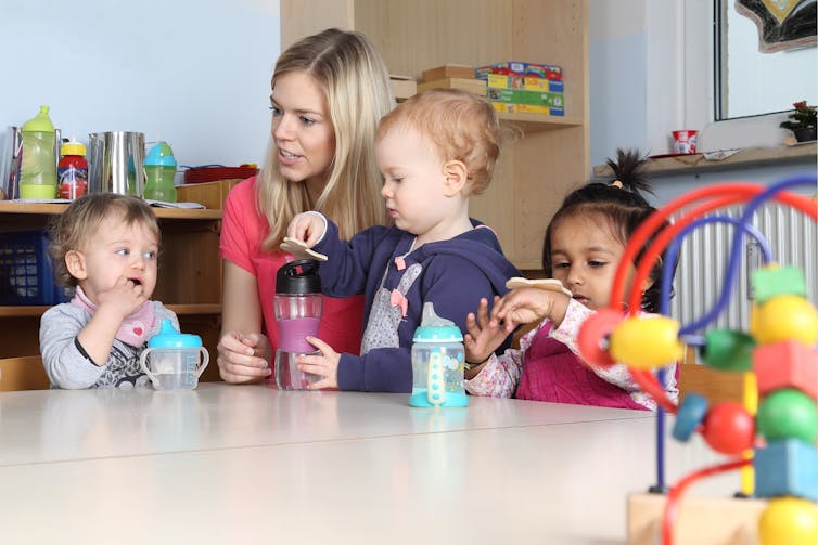 Childhood educator helping children play.