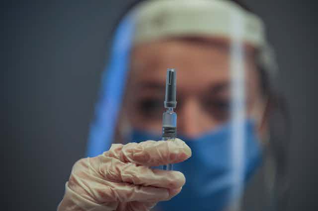 Health-care worker holding a vaccine