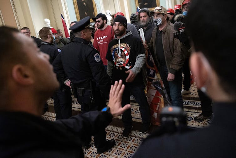 Police officers attempt to stop a pro-Trump that has invaded the US Capitol.