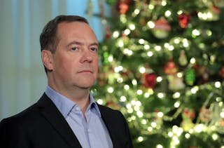Dmitrij Miedwiediew, rosyjski polityk w średnim wieku, pozuje przed choinką.