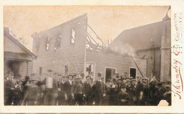 An armed mob of white insurrections in front of the Black newspaper building they burned.