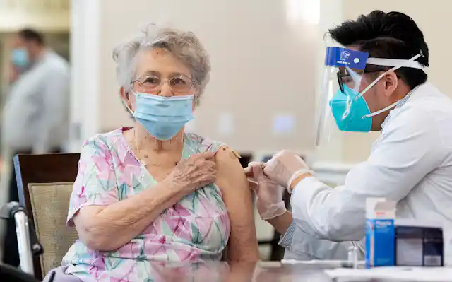 A woman is vaccinated in a nursing home.