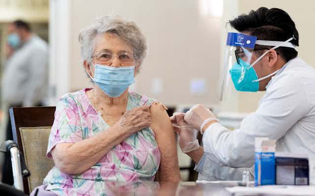 A woman is vaccinated in a nursing home.
