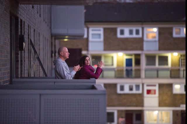 A couple clap for the NHS from their flat balcony.