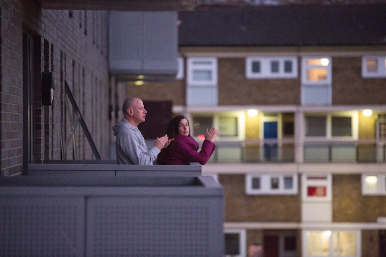 A couple clap for the NHS from their flat balcony.