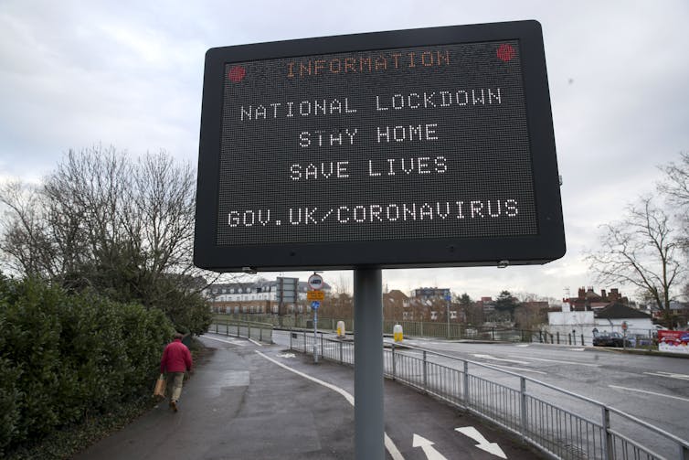A road sign carrying public information message urging drivers to stay at home.