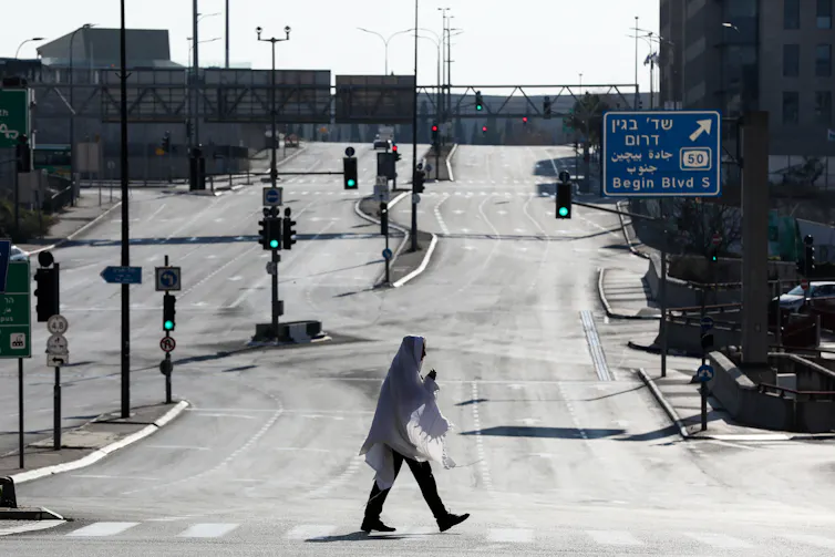 View of empty roads with solitary person walking.
