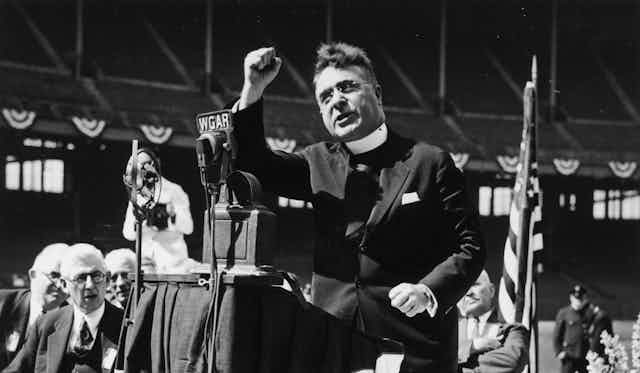 Father Charles Coughlin delivers a radio speech, circa 1930s.