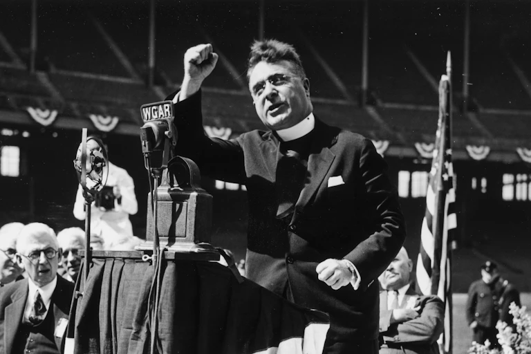 Father Charles Coughlin delivers a radio speech, circa 1930s.