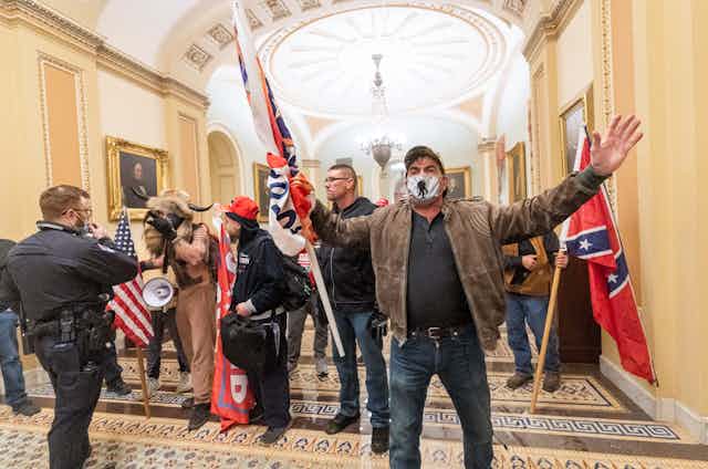 Rioters carrying white supremacist symbols inside the Capitol