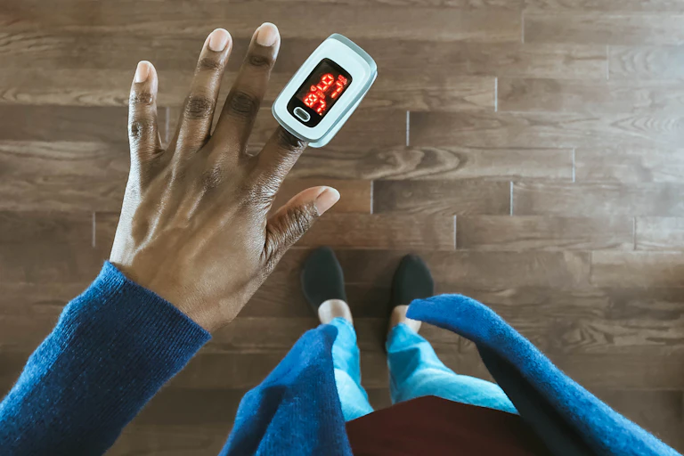 A woman uses a pulse oximeter.