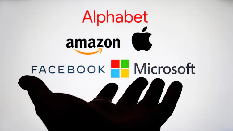 A palm above which the logos of Big Tech companies are arranged on a screen