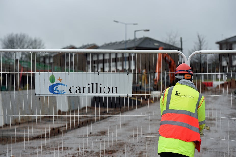 Workman closing barrier with a Carillion sign on it. 
