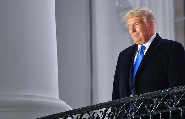 US President Donald Trump stands on the White House balcony after Judge Amy Coney Barrett was sworn in as a US Supreme Court Associate Justice during a ceremony on the South Lawn of the White House.