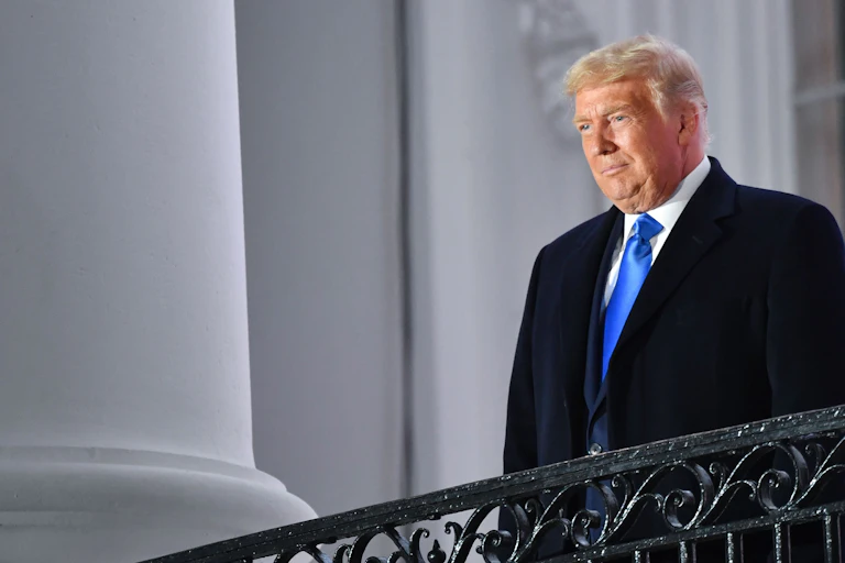 US President Donald Trump stands on the White House balcony after Judge Amy Coney Barrett was sworn in as a US Supreme Court Associate Justice during a ceremony on the South Lawn of the White House.