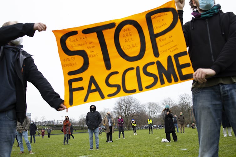 Dutch demonstrators carry a Stop Facism sign at a protest against the raid on the U.S. Capitol