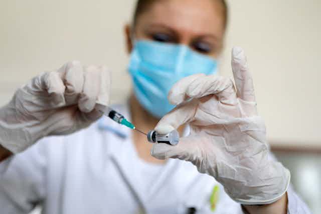 A nurse prepares a dose of the Pfizer vaccine in Serbia.