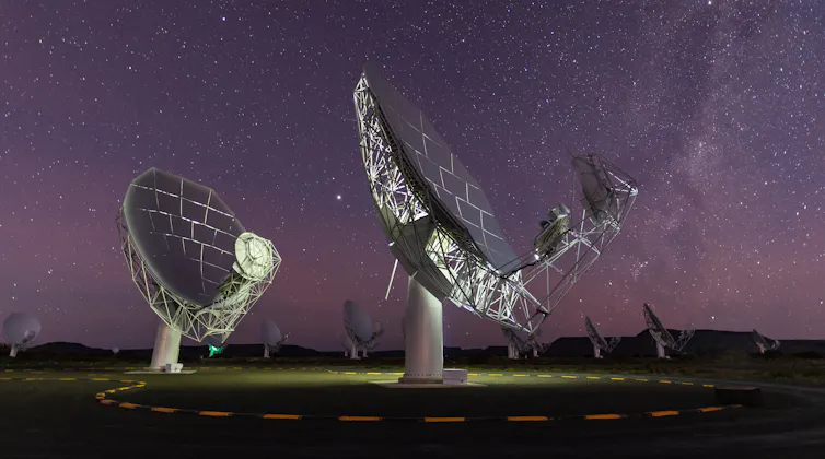 Deux énormes antennes paraboliques sont pointées vers le ciel nocturne