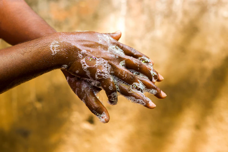 Mans hands with soap and water.