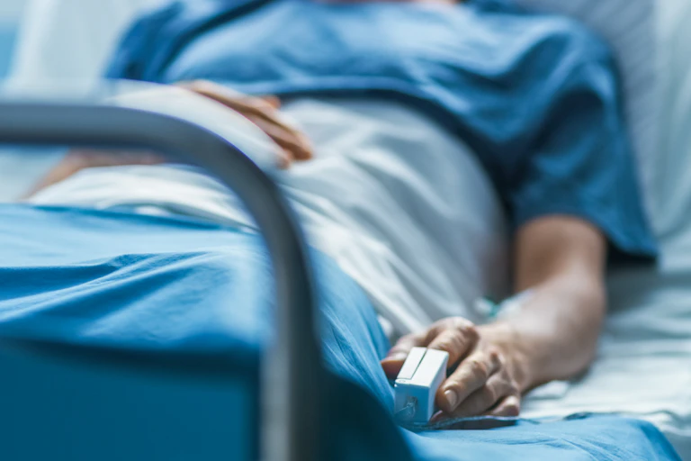A man lying in a hospital bed.