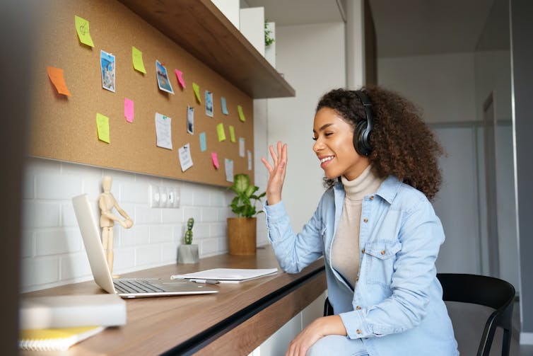 Female adult wearing headphones and talking with computer