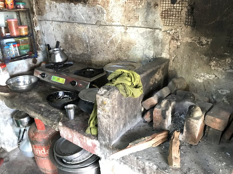 Metal stove on brick shelf with kerosene tank below.
